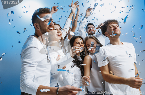 Image of Group of cheerful joyful young people standing and celebrating together over blue background