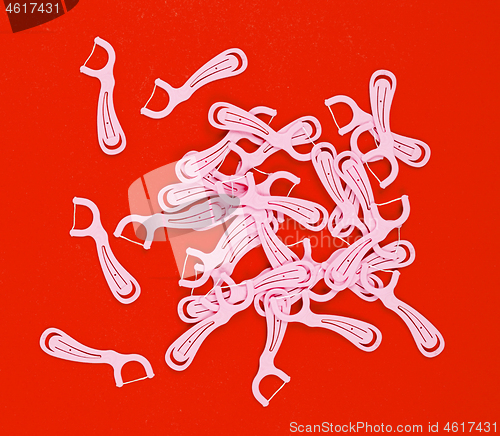 Image of Floss toothpicks isolated on red background