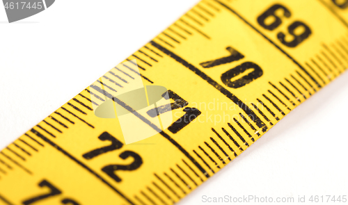 Image of Close-up of a yellow measuring tape isolated on white - 71