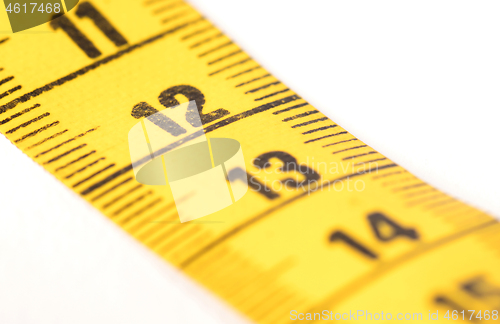 Image of Close-up of a yellow measuring tape isolated on white - 12