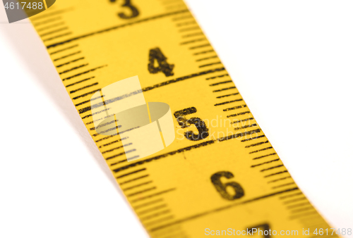 Image of Close-up of a yellow measuring tape isolated on white - 5