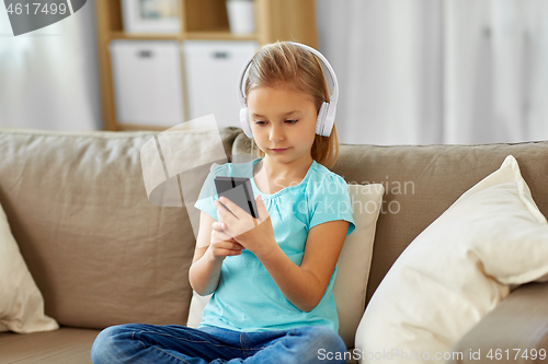 Image of girl in headphones listening to music at home