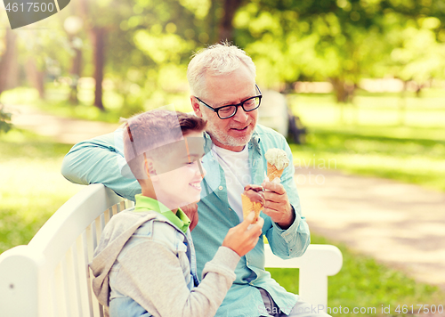 Image of old man and boy eating ice cream at summer park