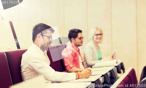 Image of group of students with notebooks in lecture hall