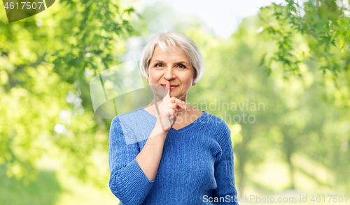 Image of senior woman making shush gesture