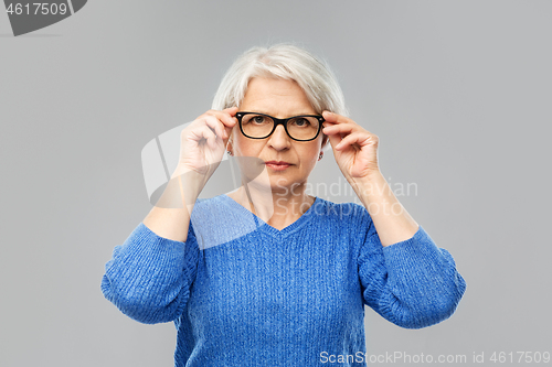 Image of portrait of senior woman in glasses over grey