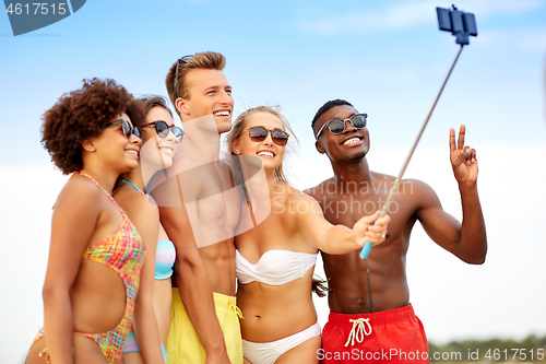 Image of happy friends taking selfie on summer beach