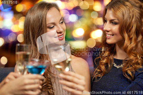 Image of happy women clinking glasses at night club