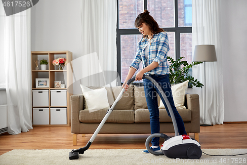 Image of asian woman with vacuum cleaner at home