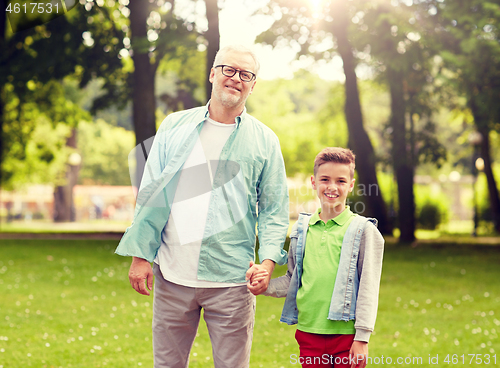 Image of grandfather and grandson walking at summer park