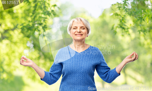 Image of smiling senior woman in blue sweater chilling