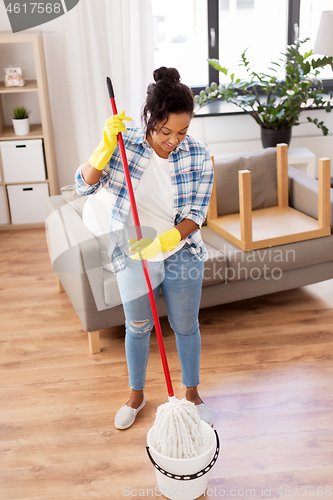 Image of african woman or housewife cleaning floor at home