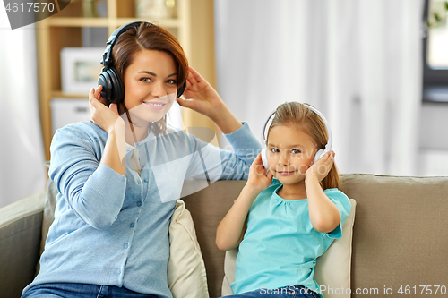 Image of mother and daughter in headphones listen to music