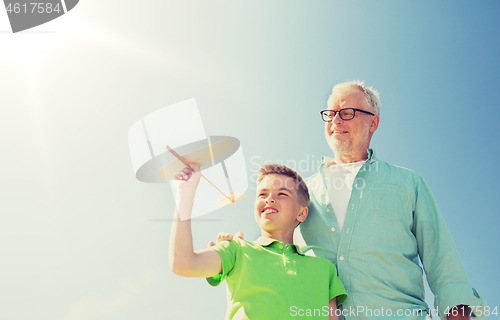 Image of senior man and boy with toy airplane over sky