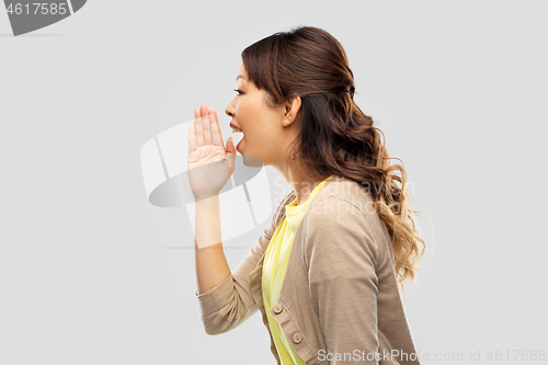 Image of young asian woman calling for someone