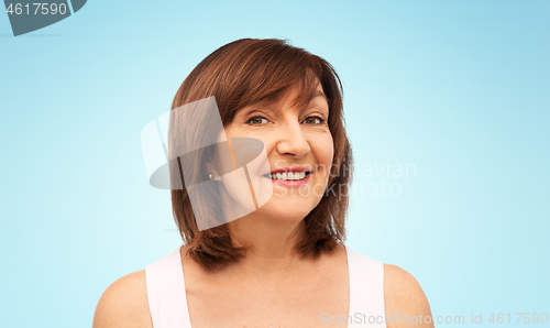 Image of portrait of smiling senior woman over blue