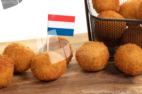 Image of Dutch traditional snack bitterbal on a serving board, dutch flag