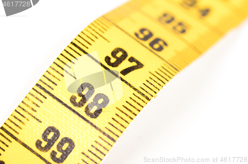 Image of Close-up of a yellow measuring tape isolated on white - 98