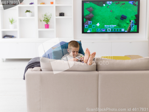 Image of little boy playing games on smartphone