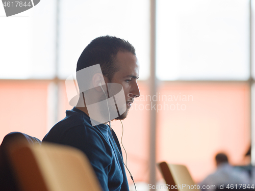 Image of business man listening music on headphones