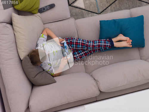 Image of top view of  little boy playing games on tablet computers