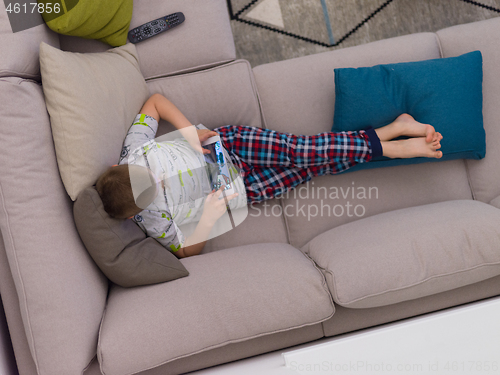 Image of top view of  little boy playing games on tablet computers