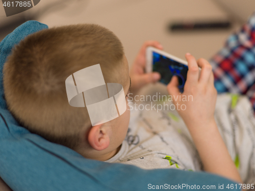 Image of little boy playing games on smartphone