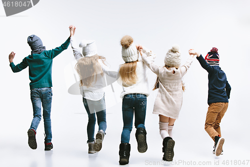Image of Group of kids in bright winter clothes, isolated on white