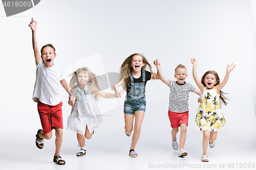 Image of Group fashion cute preschooler kids friends posing together and looking at camera white background