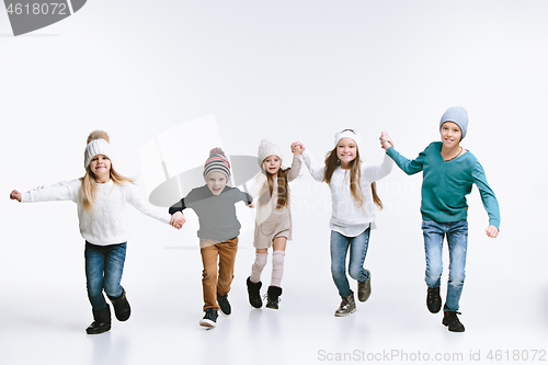 Image of Group of kids in bright winter clothes, isolated on white