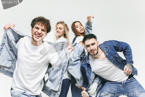 Image of Group of smiling friends in fashionable jeans