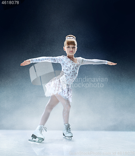 Image of Little girl figure skating at the indoor ice arena.