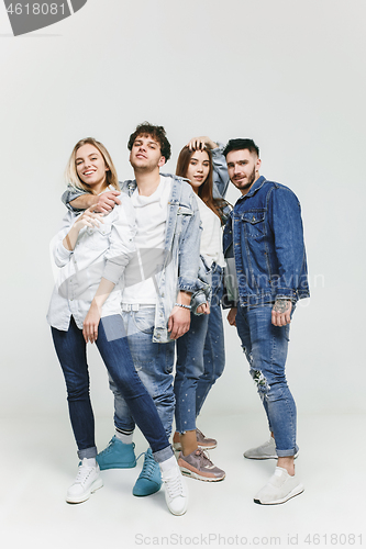 Image of Group of smiling friends in fashionable jeans