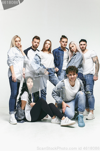 Image of Group of smiling friends in fashionable jeans