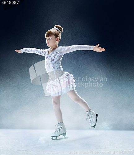 Image of Little girl figure skating at the indoor ice arena.