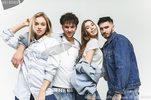 Image of Group of smiling friends in fashionable jeans