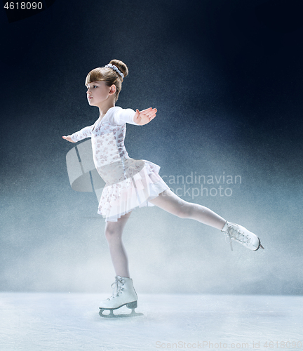 Image of Little girl figure skating at the indoor ice arena.