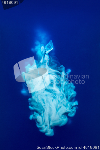 Image of Abstract pattern falling into the water drop of blue ink - cyan ink dissolved in water