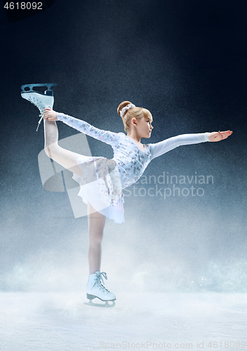 Image of Little girl figure skating at the indoor ice arena.