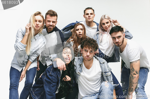 Image of Group of smiling friends in fashionable jeans