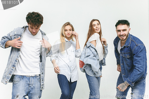 Image of Group of smiling friends in fashionable jeans