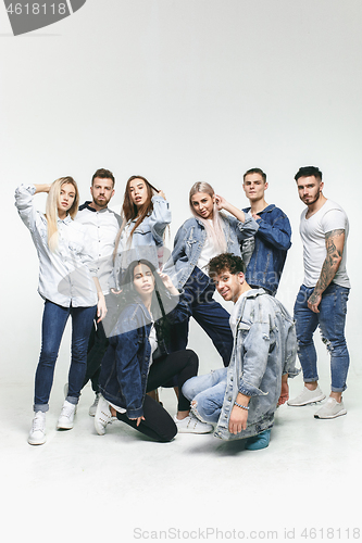 Image of Group of smiling friends in fashionable jeans