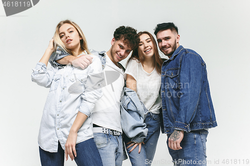 Image of Group of smiling friends in fashionable jeans