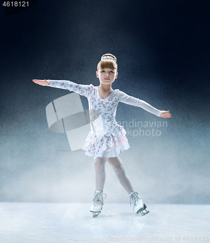 Image of Little girl figure skating at the indoor ice arena.