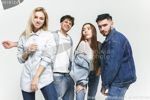 Image of Group of smiling friends in fashionable jeans