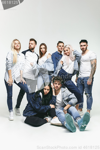 Image of Group of smiling friends in fashionable jeans