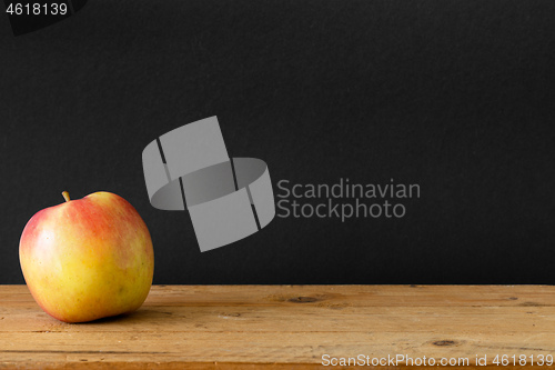 Image of black background apple wooden table