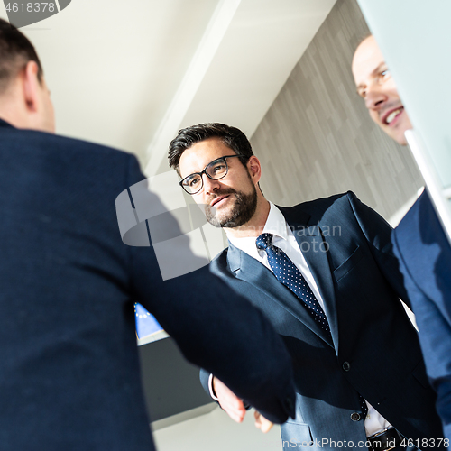 Image of Group of confident business people greeting with a handshake at business meeting in modern office or closing the deal agreement by shaking hands.