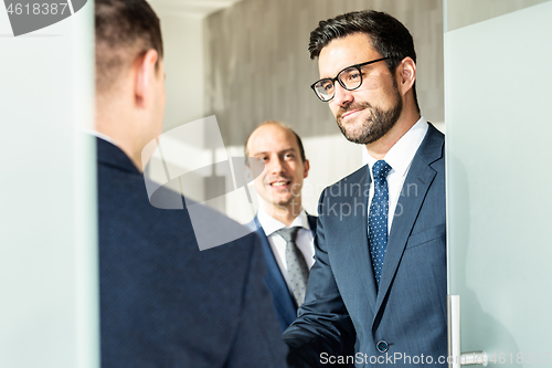 Image of Group of confident business people greeting with a handshake at business meeting in modern office or closing the deal agreement by shaking hands.