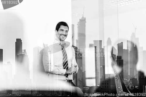 Image of Confident company leader on business meeting against new york city manhattan buildings and skyscrapers window reflection.